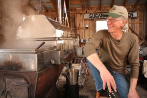 Don Olson, owner of the Blue Rock Farm sitting beside his sap evaporator. photo by Paul King. 