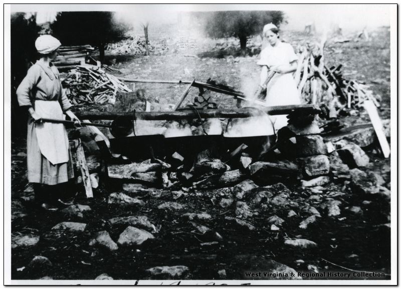 The old fashioned way. Dahmer Family Members Estella and Jenny Boiling Maple Syrup, Pendleton County. Courtesy of West Virginia and Regional History Collection, West Virginia University Libraries